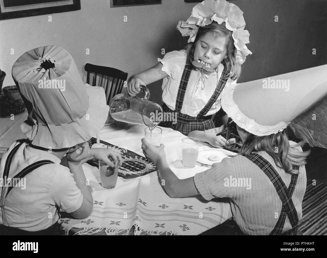 Natale negli anni cinquanta. Tre bambini su una festa di natale. Bevono limonata e mangiare i cookie. Svezia 1953 Foto Stock