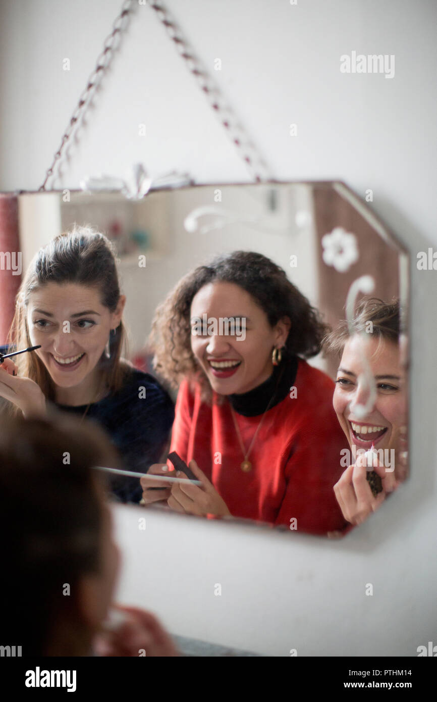 Giovani donne amici ottenere pronto, applicando il trucco in Specchio bagno Foto Stock