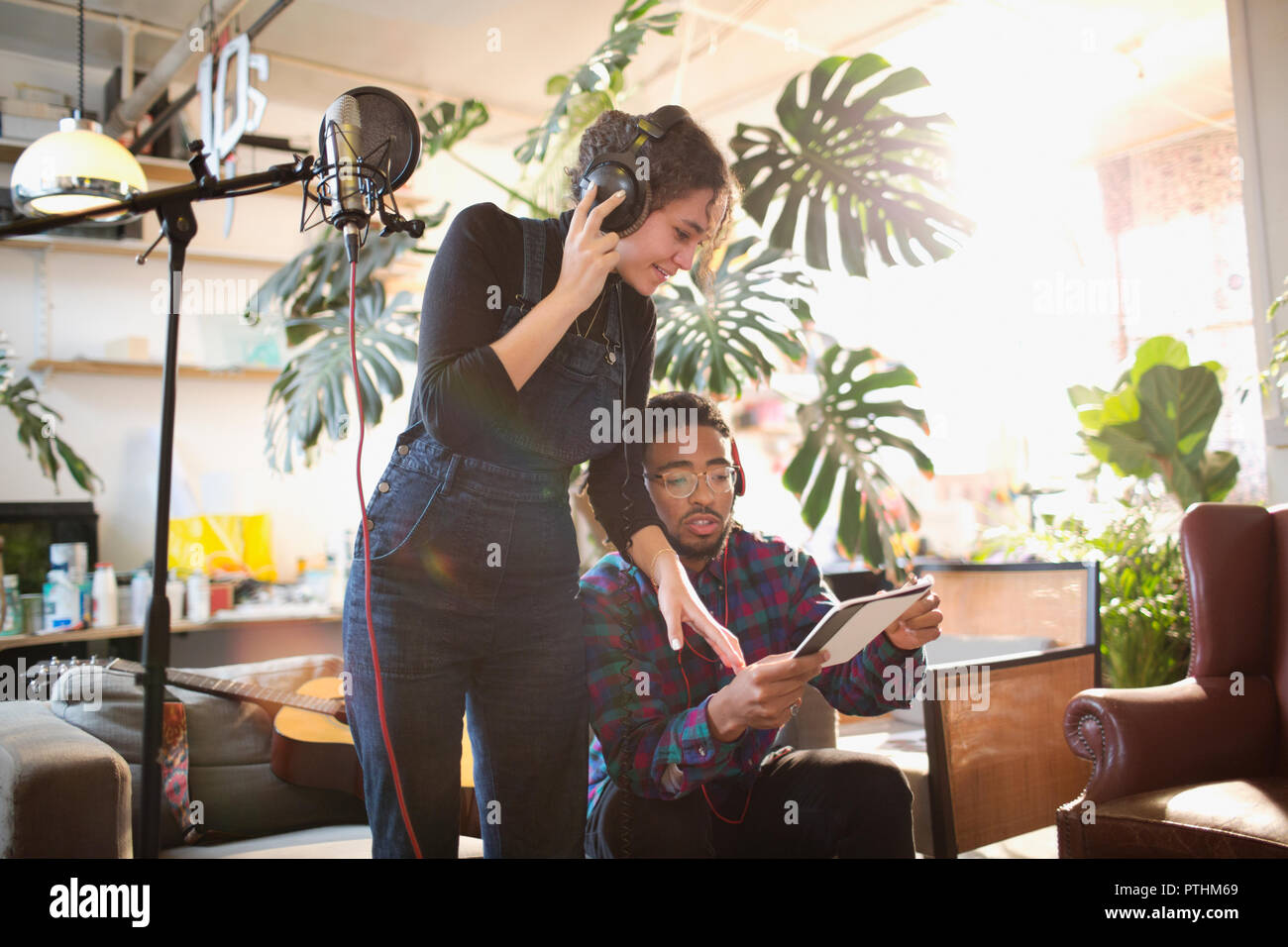 Giovane uomo e donna sulla registrazione di musica in appartamento Foto Stock
