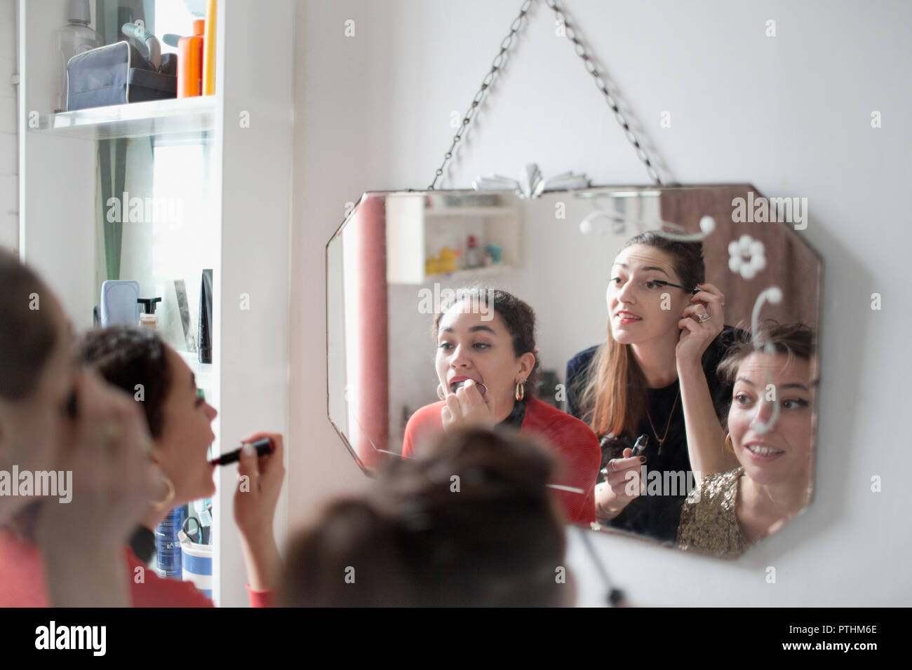 Giovani donne amici ottenere pronto, applicando il trucco in Specchio bagno Foto Stock