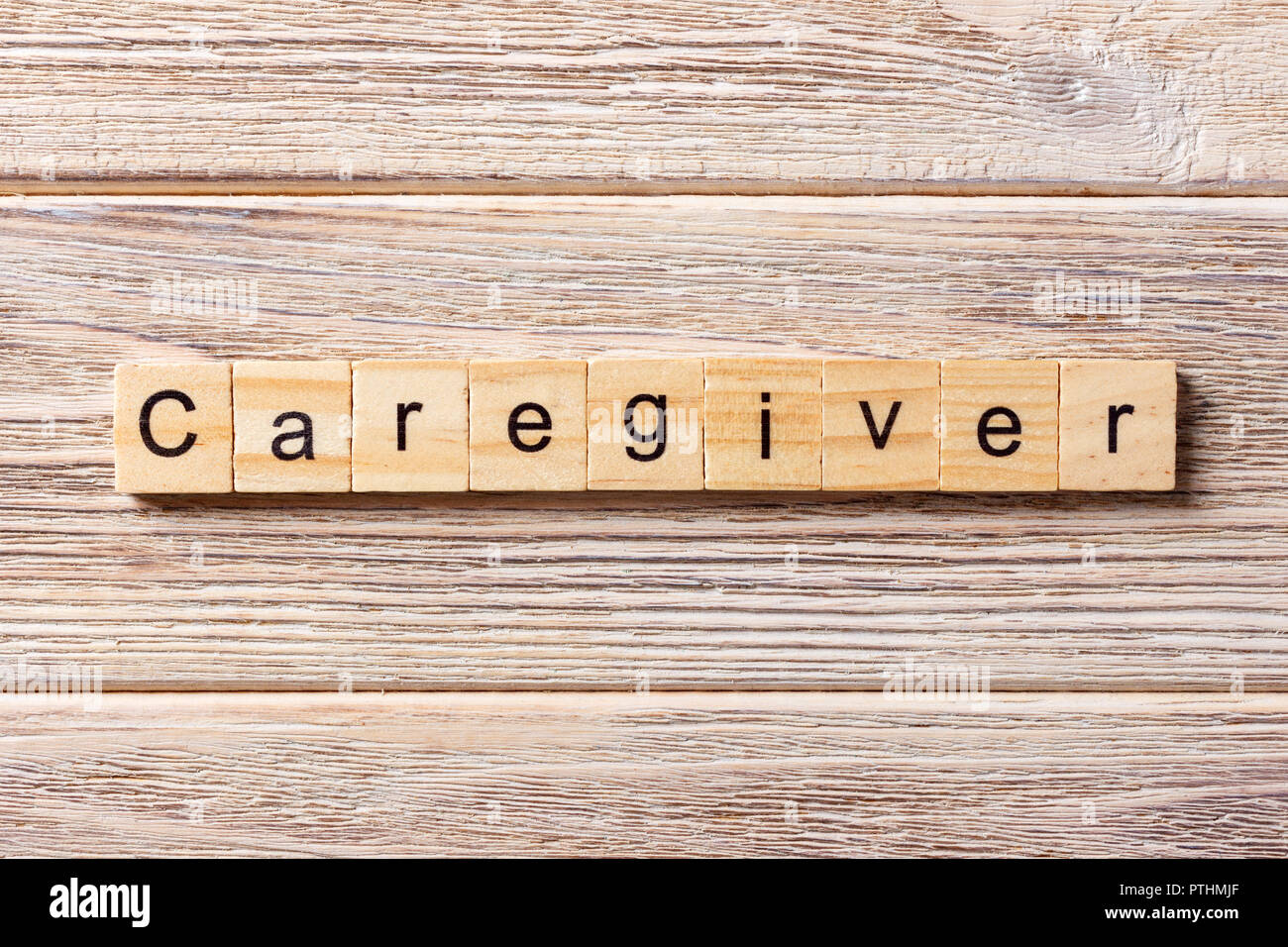 Il caregiver parola scritta sul blocco di legno. Il caregiver testo sul tavolo, concetto. Foto Stock