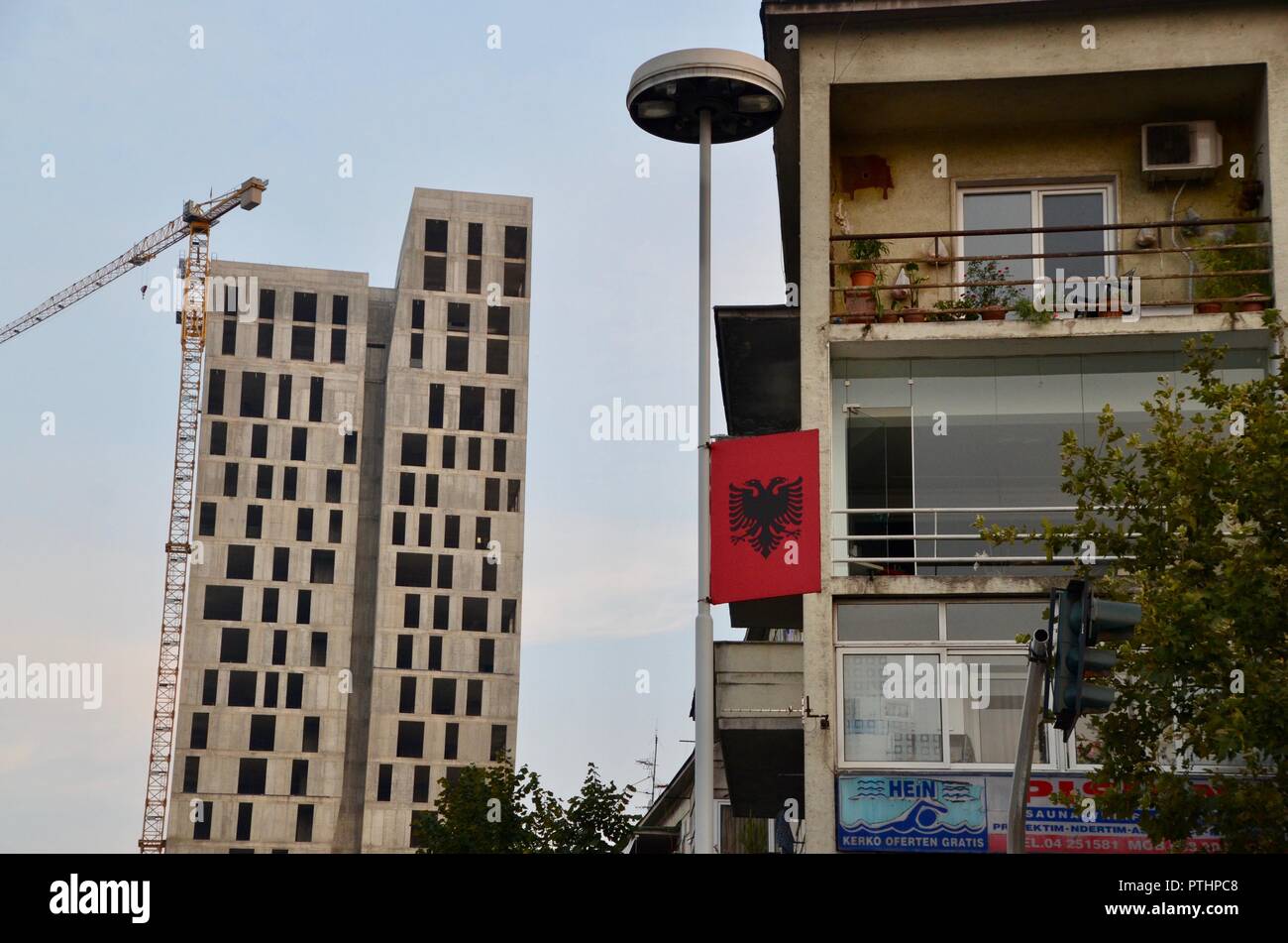 Constarsting apratment blocchi a Tirana in Albania; vecchio rispetto all emergere di un nuovo grattacielo Foto Stock