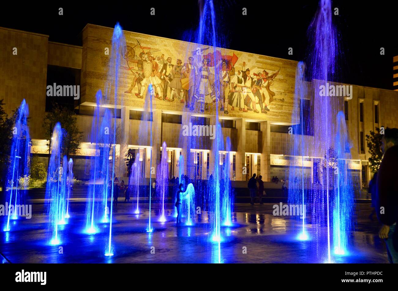 Museo di Storia Nazionale Tirana Albania durante la notte con illuminato di acqua colorata fontane Foto Stock