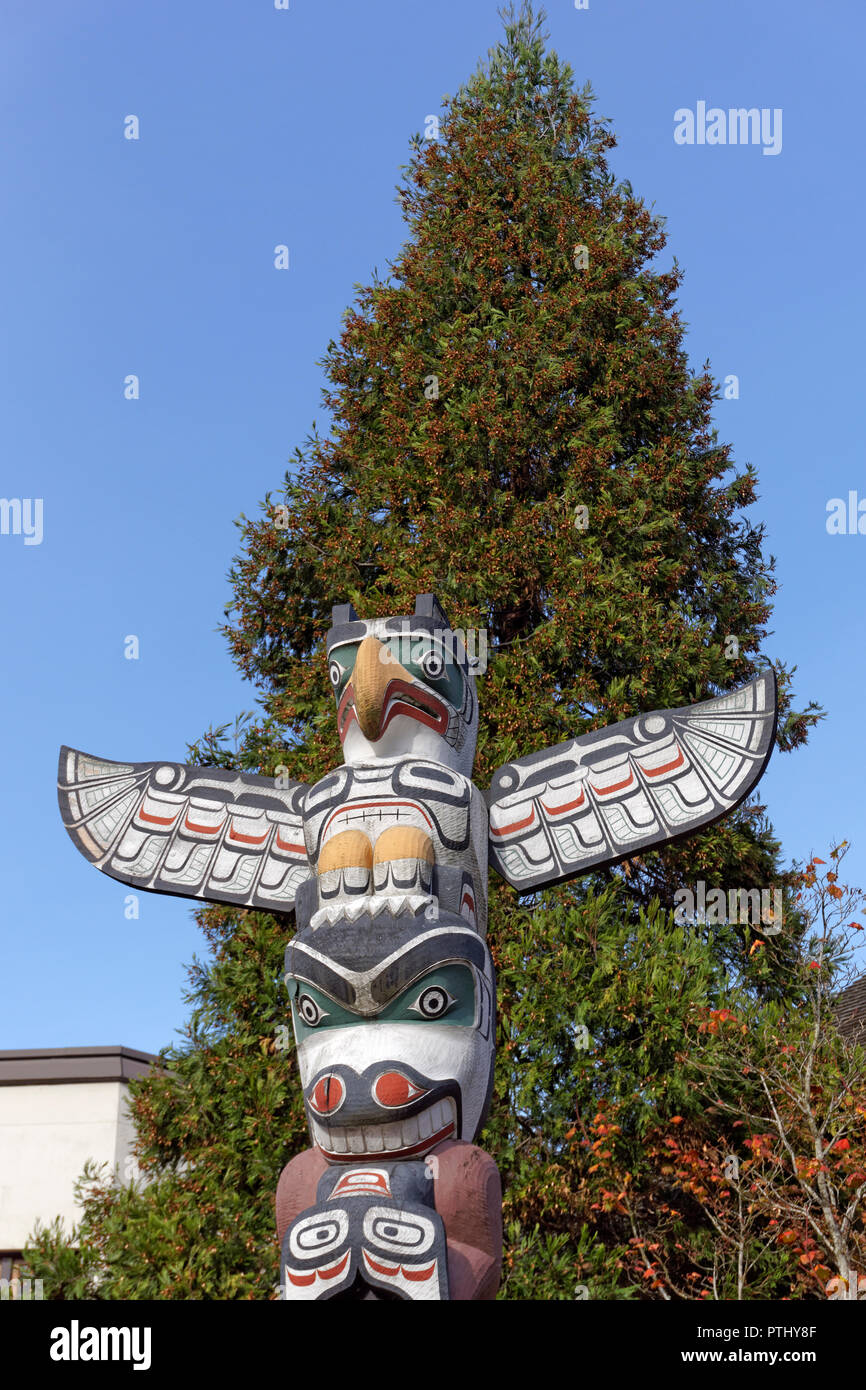 Thunderbird scultura sulla sommità della vittoria attraverso onore totem pole davanti a Brock House, University of British Columbia, Vancouver, BC, Canada Foto Stock