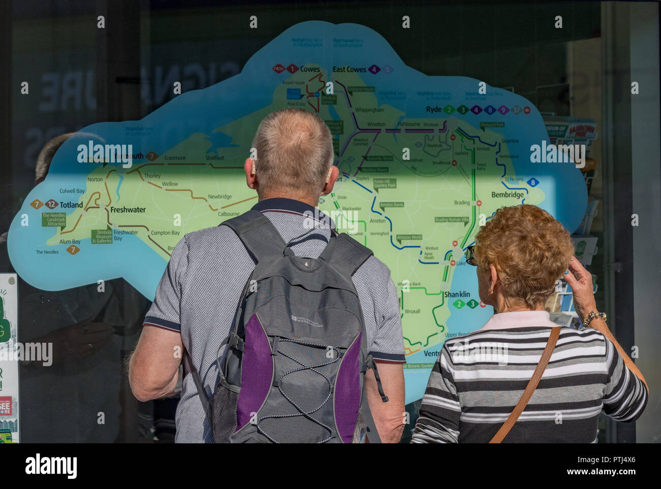 Un vecchio o coppia di anziani guardando una mappa turistica in forma di Isola di Wight a ryde esplanade stazione degli autobus. Foto Stock