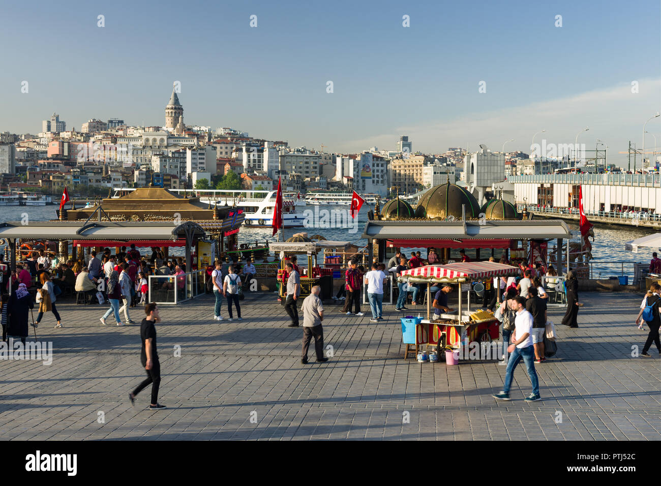 Eminonu bazaar con stand gastronomici e ristoranti, traghetti, lo stretto del Bosforo, Torre Galata, il Ponte di Galata Karakoy e può essere visto in background, Foto Stock