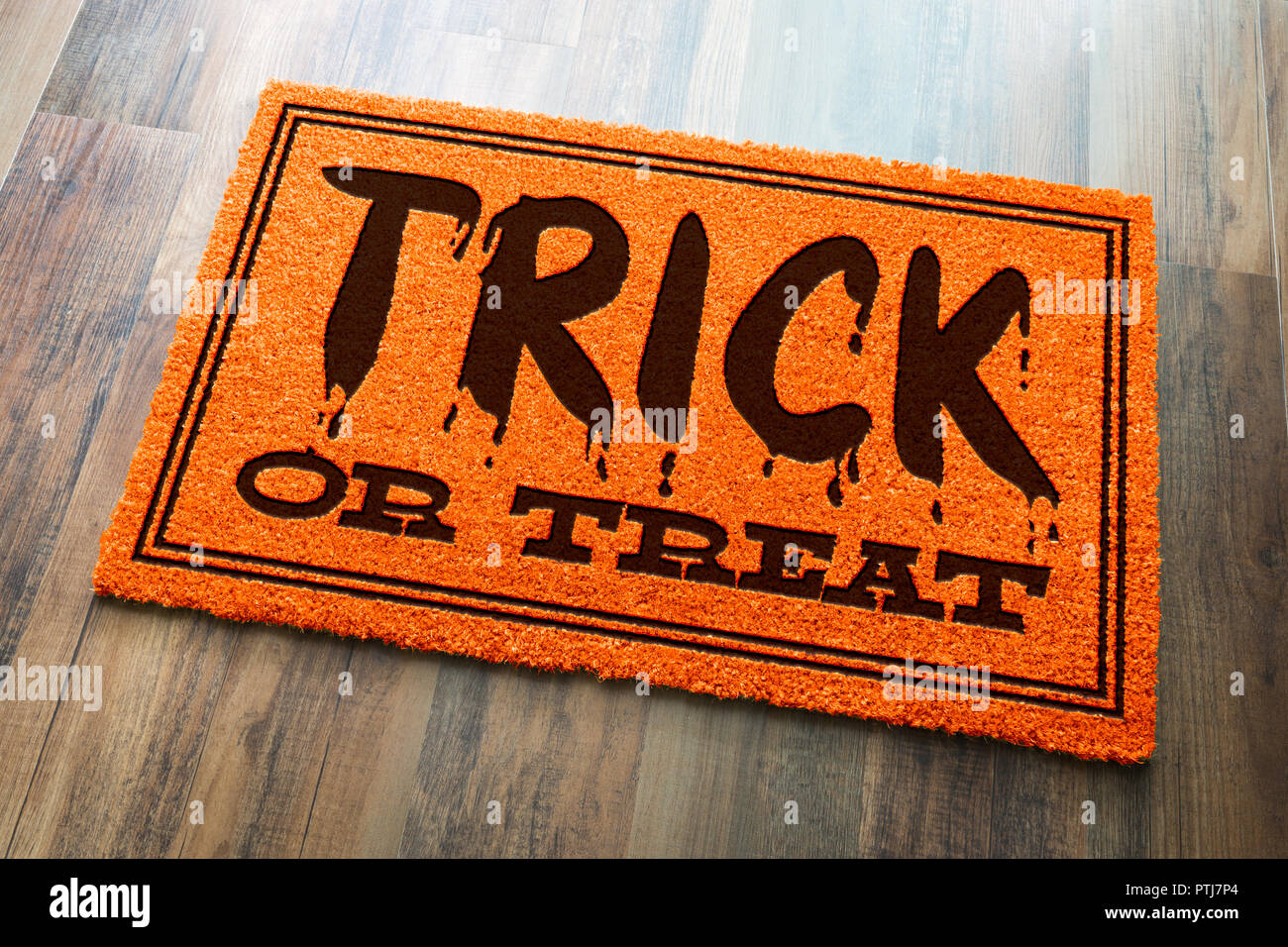Dolcetto o scherzetto Halloween Orange tappeto di benvenuto sul pavimento di legno dello sfondo. Foto Stock