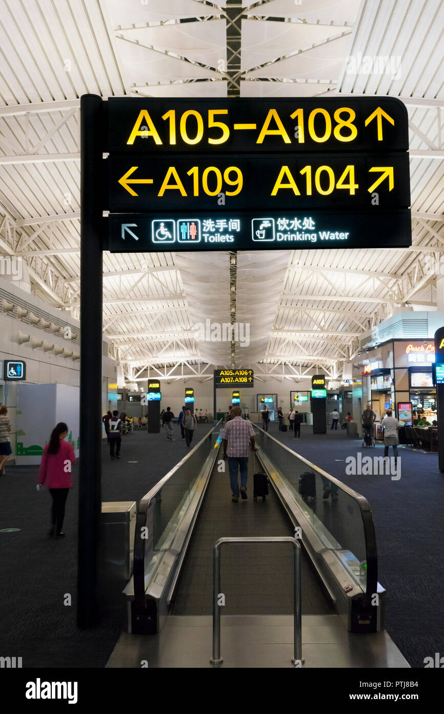 Tapis Roulants e segno di carattere informativo a Guangzhou Baiyun International Airport, Cina. Foto Stock