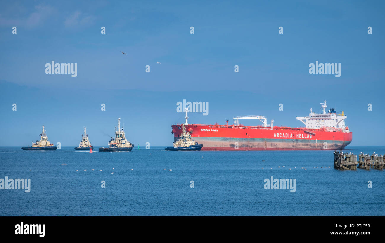 Il grezzo petroliera Mar Egeo potenza viene portato nella guarnizione Sands port da quattro rimorchiatori. Foto Stock