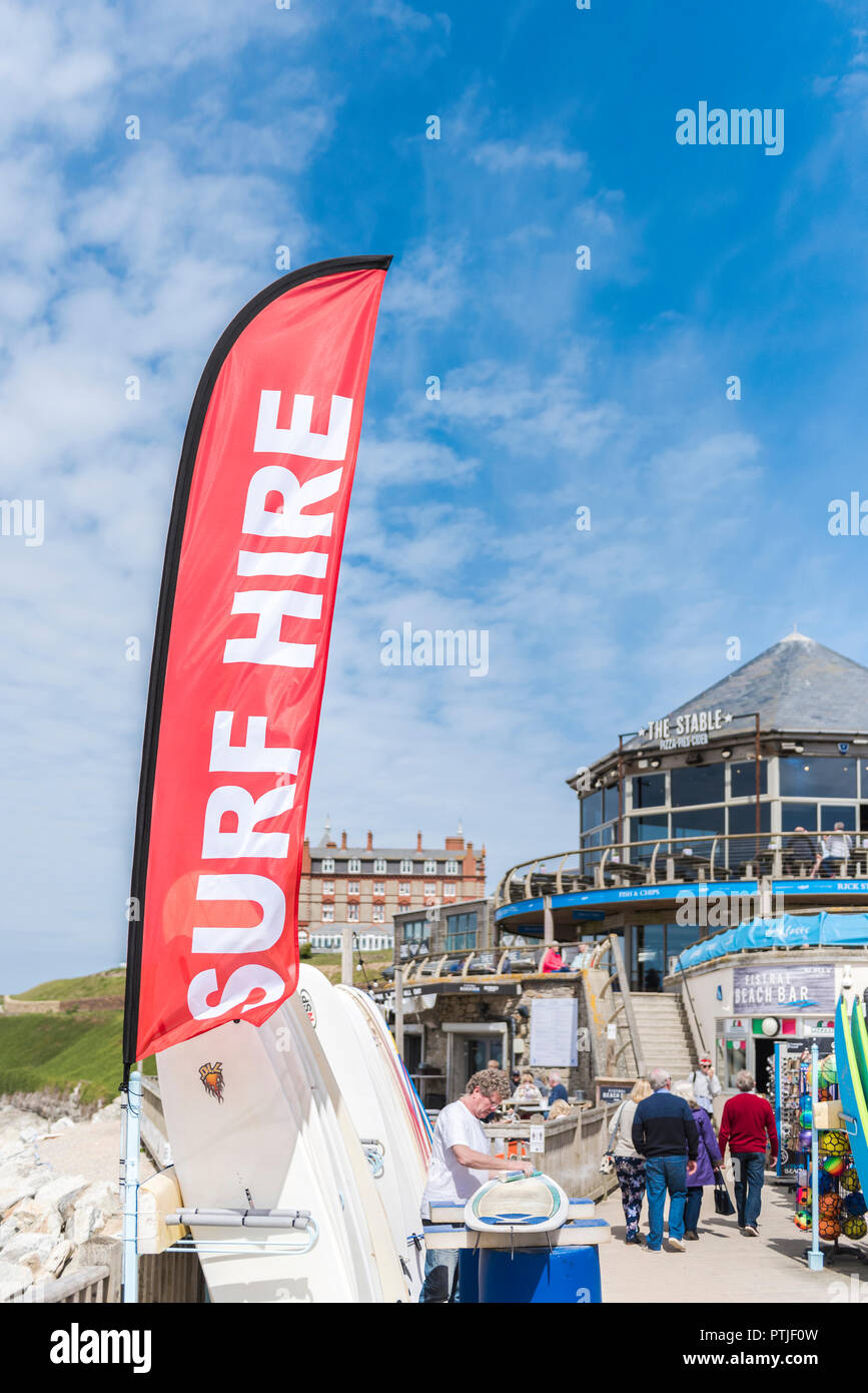 Un colorato banner pubblicitari noleggio surf a Fistral Beach in Newquay in Cornovaglia. Foto Stock