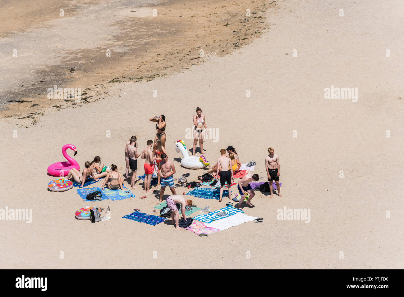Un folto gruppo di giovani che si diverte su una spiaggia di Newquay in Cornovaglia. Foto Stock