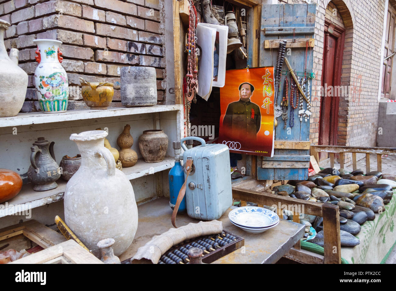 Kashgar, Xinjiang, Cina : Un Mao Zedong calendario appeso alla porta di un negozio di antiquariato nel centro storico della città. Foto Stock