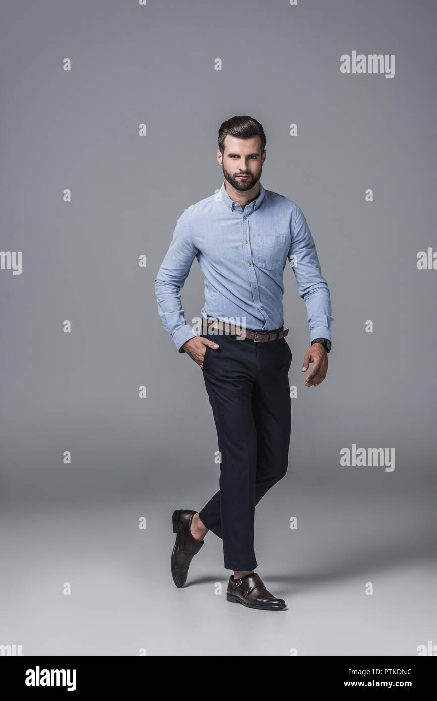 Elegante uomo d affari in abbigliamento formale, su grigio Foto Stock