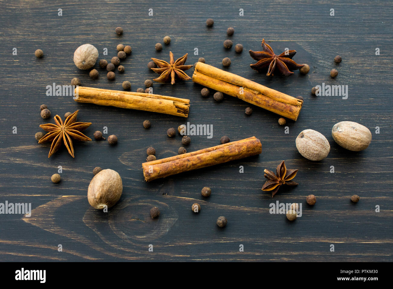 Le spezie intere al buio su un sfondo di legno Foto Stock