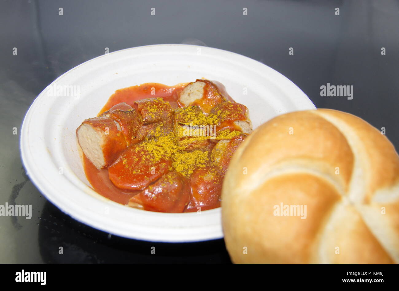 Currywurst mit Brötchen auf Pappteller Foto Stock