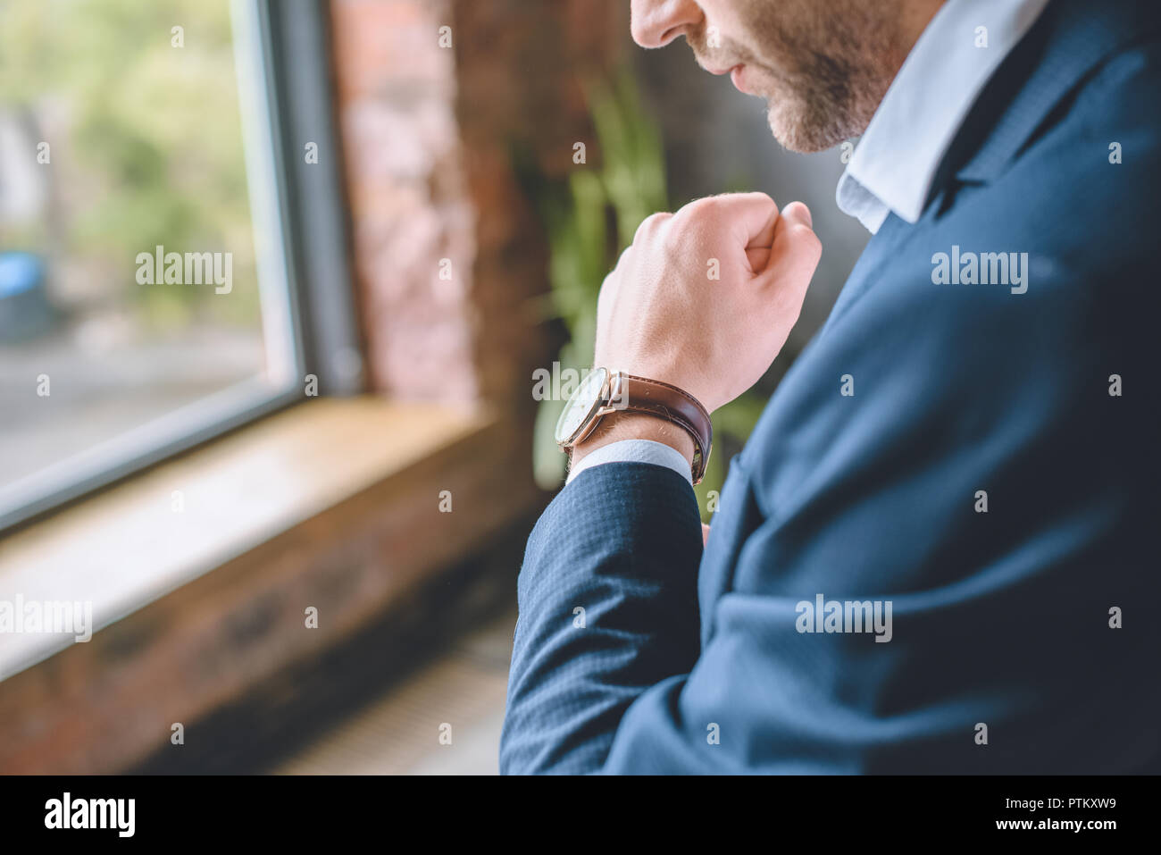 Immagine ritagliata di imprenditore a mettere su un orologio da polso a casa Foto Stock