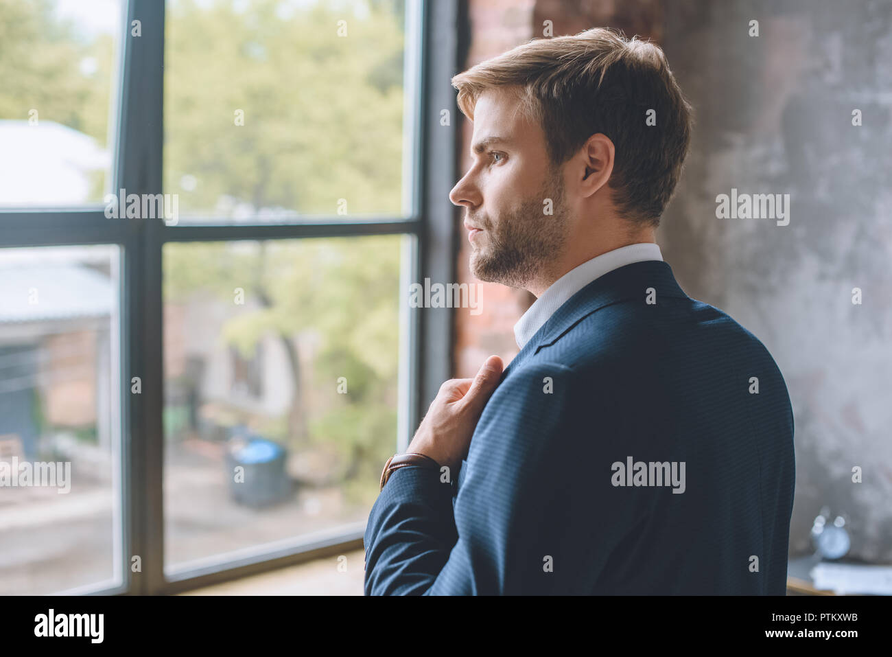 Messa a fuoco selettiva del giovane imprenditore mettendo sulla camicia a casa Foto Stock