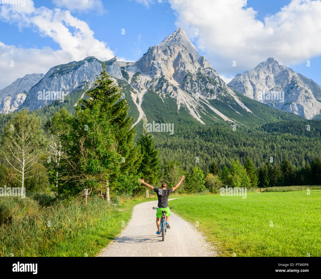 Ciclista con mountain bike a mani libere, con i bracci sollevati, sul percorso ciclabile Via Claudia Augusta, di attraversamento delle Alpi Foto Stock