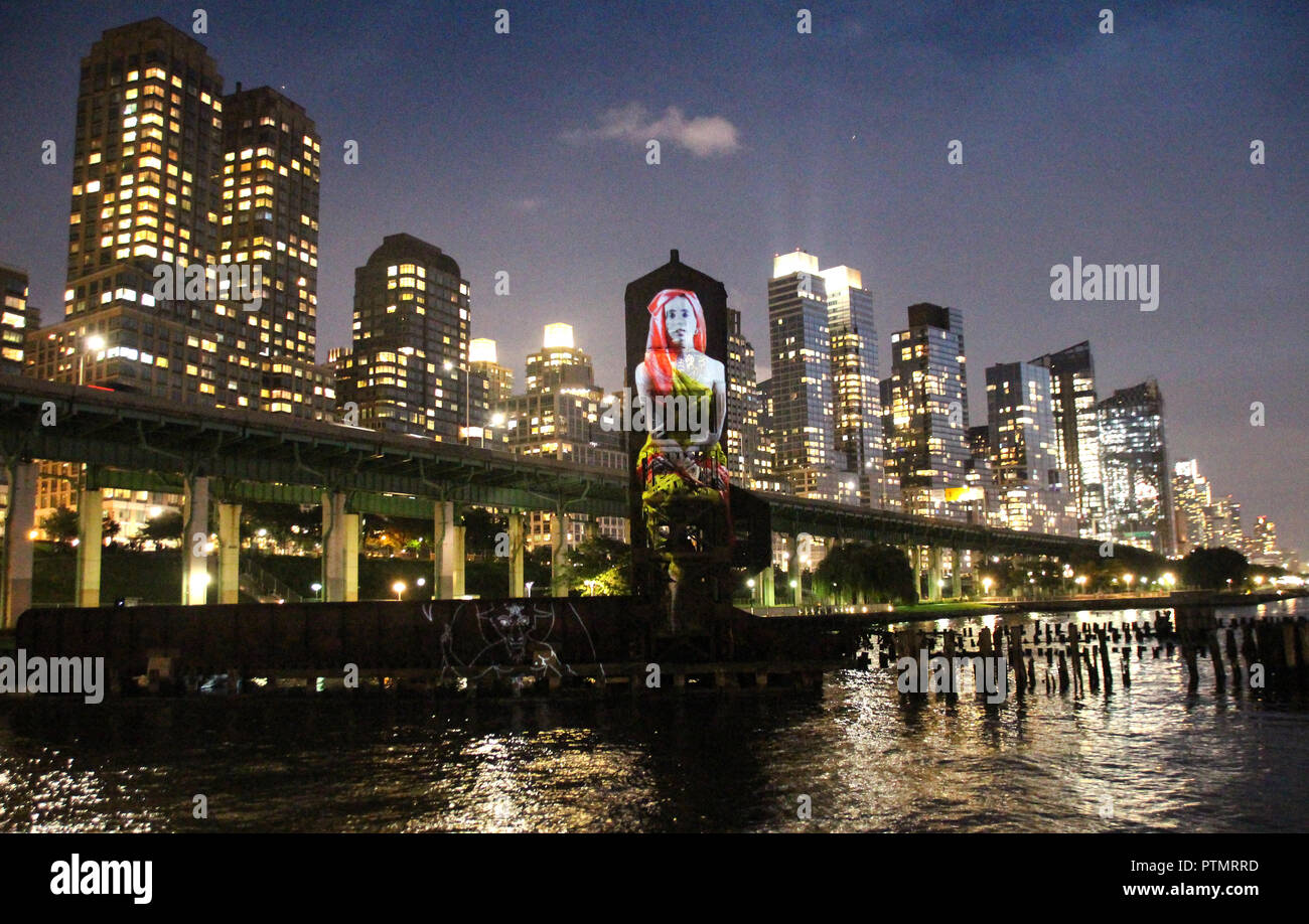 New York, Stati Uniti d'America. 09oct, 2018. New York artista Tony Oursler ha trasformato un molo scartati nel fiume Hudson fuori Manhattan in un arte di installazione. Oursler progetti video arte sul vecchio ponte della gru del molo, accompagnato da musica e suono. Tra le altre cose, figure storiche o lo stemma della città di New York può essere visto. L'installazione è prevista fino al 31 Ottobre. (A dpa " progetti dell'artista video arte sul New York pier' dal 10.10.2018) Credito: Christina Horsten/dpa/Alamy Live News Foto Stock