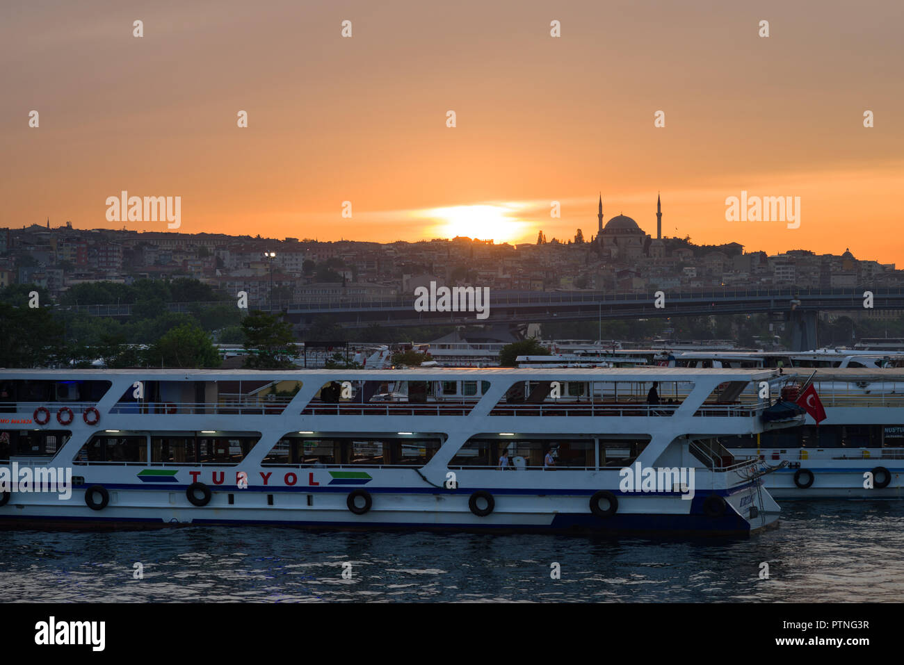 Turyol traghetti passeggeri a Golden Horn edifici e moschea di sfondo al tramonto, istanbul, Turchia Foto Stock