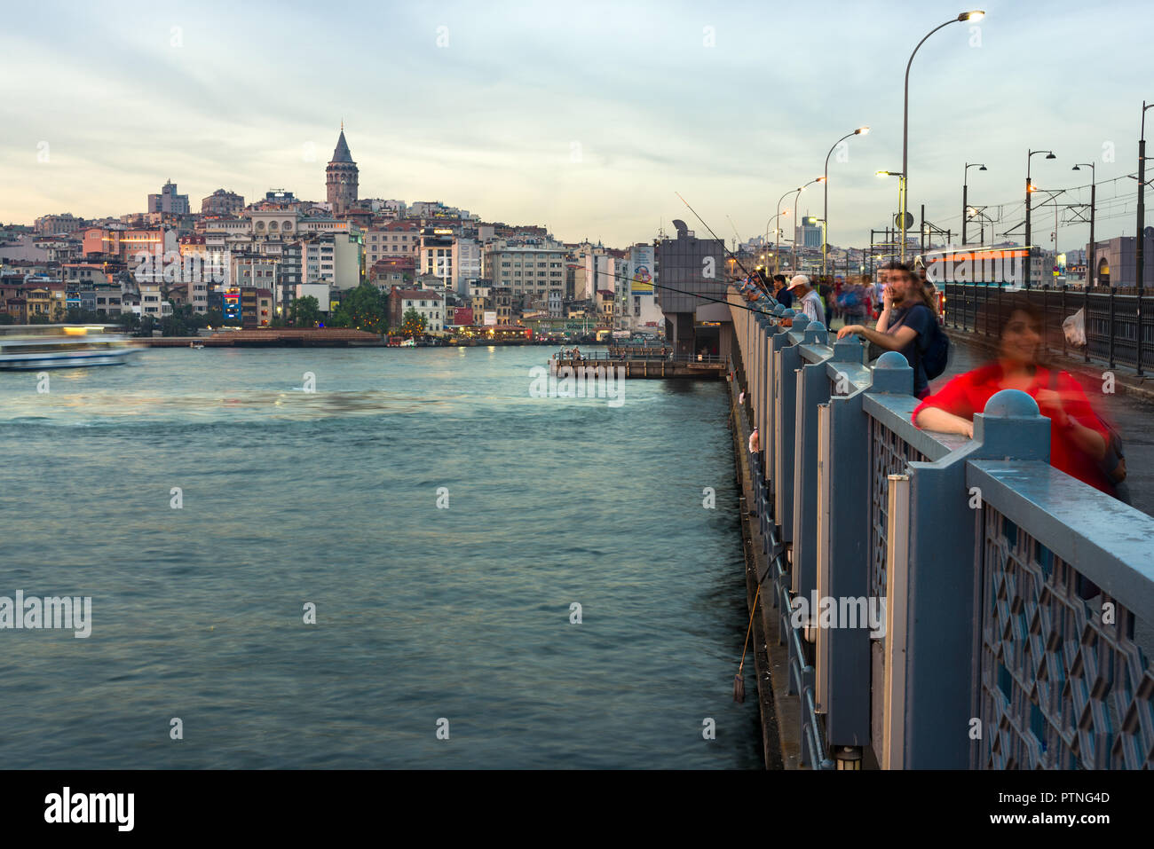 Il Ponte di Galata con pescatori pesca nel tardo pomeriggio di luce, Karakoy e Torre Galata può essere visto in lontananza, Istanbul, Turchia Foto Stock