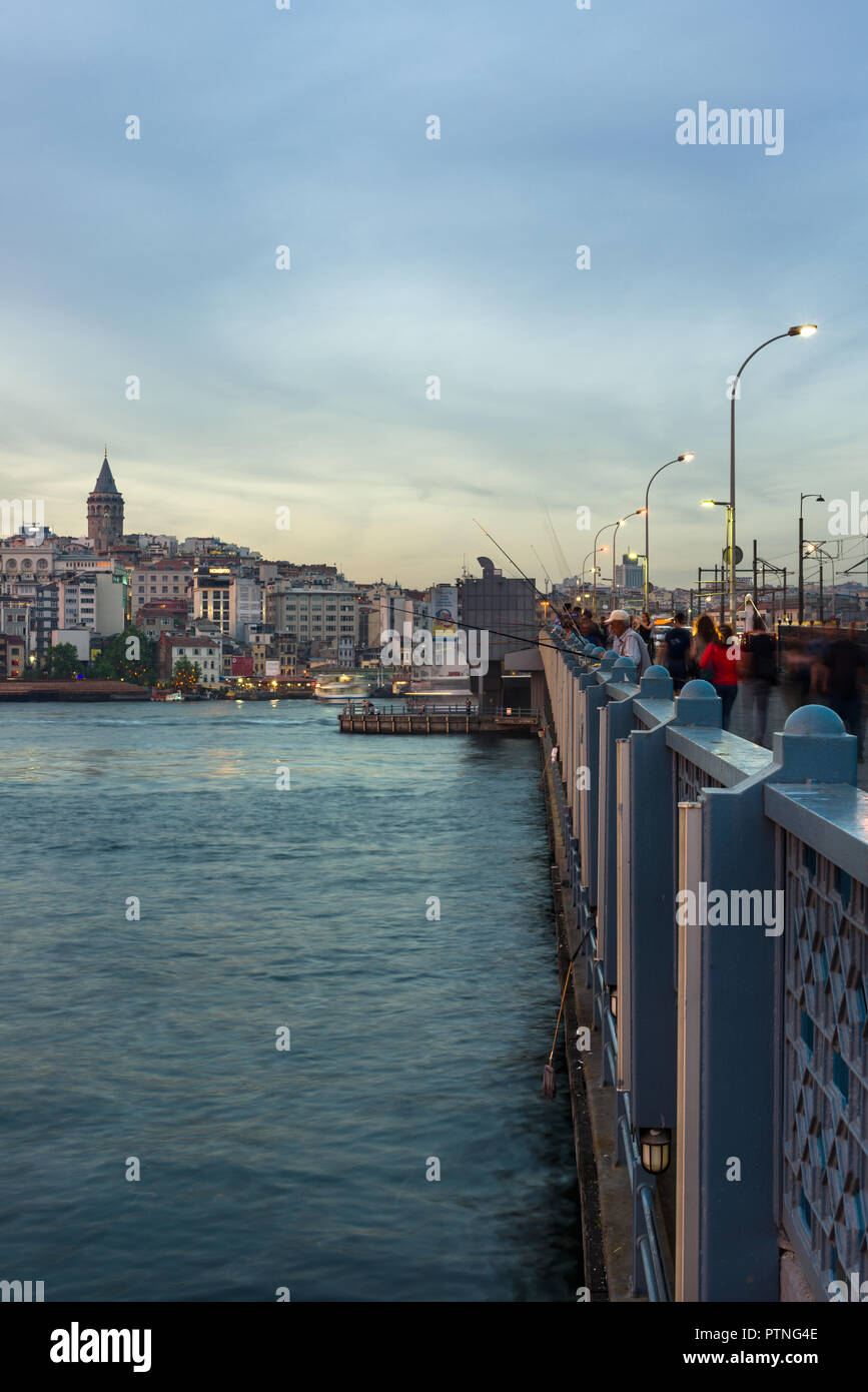 Il Ponte di Galata con pescatori pesca nel tardo pomeriggio di luce, Karakoy e Torre Galata può essere visto in lontananza, Istanbul, Turchia Foto Stock