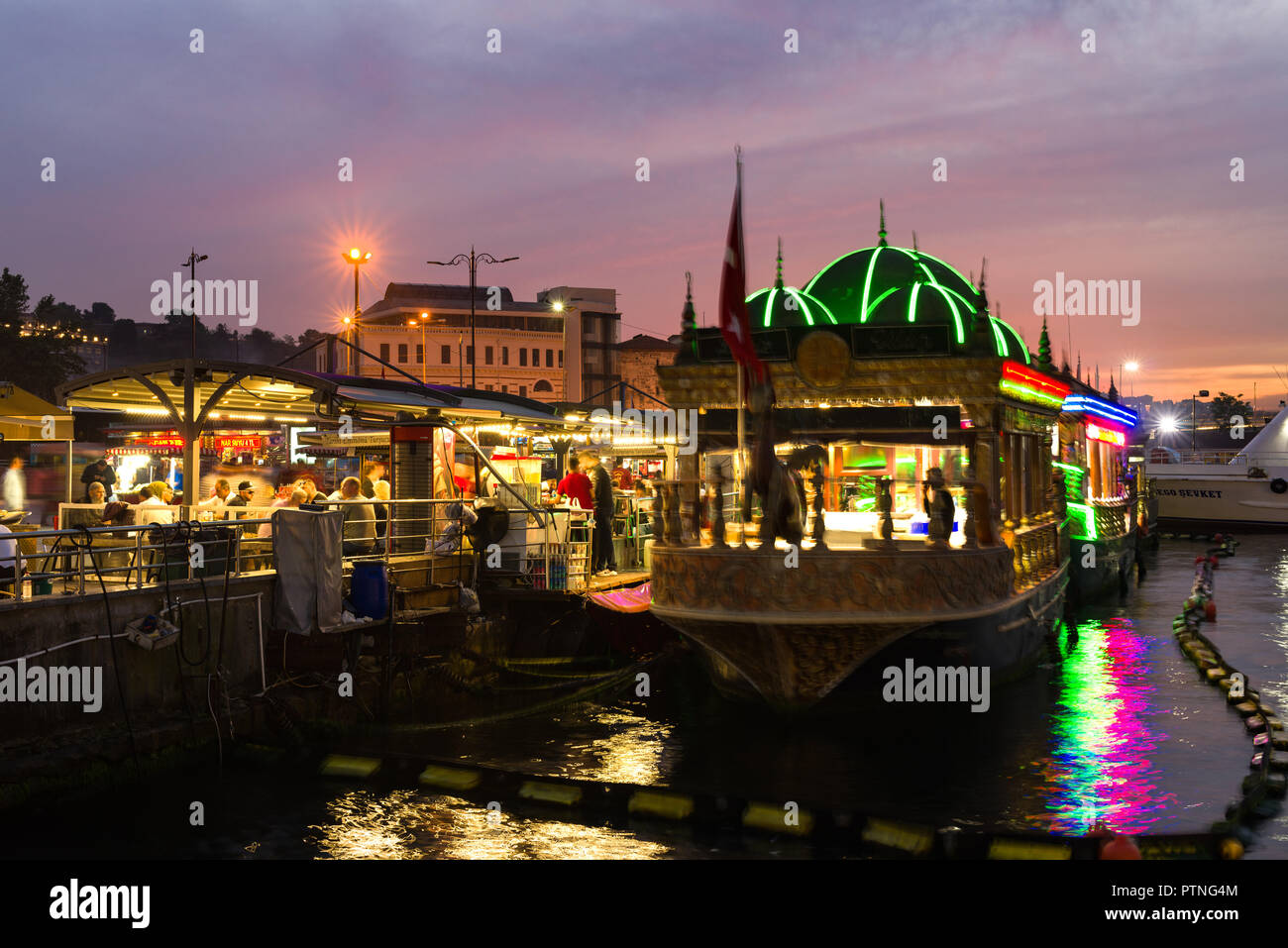 Il floating cucine di Eminonu bazaar accesa fino al crepuscolo con persone sedute in zona pranzo, Istanbul, Turchia Foto Stock