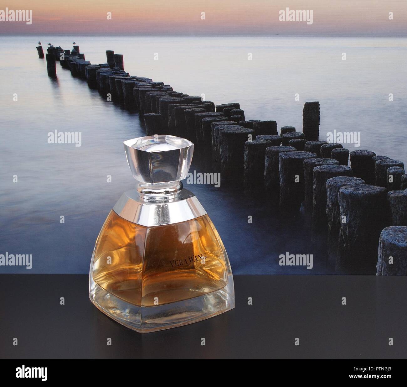 Vera Wang, fragranza per signore, grande bottiglia di profumo di fronte alla foto di un groyne in mare Foto Stock