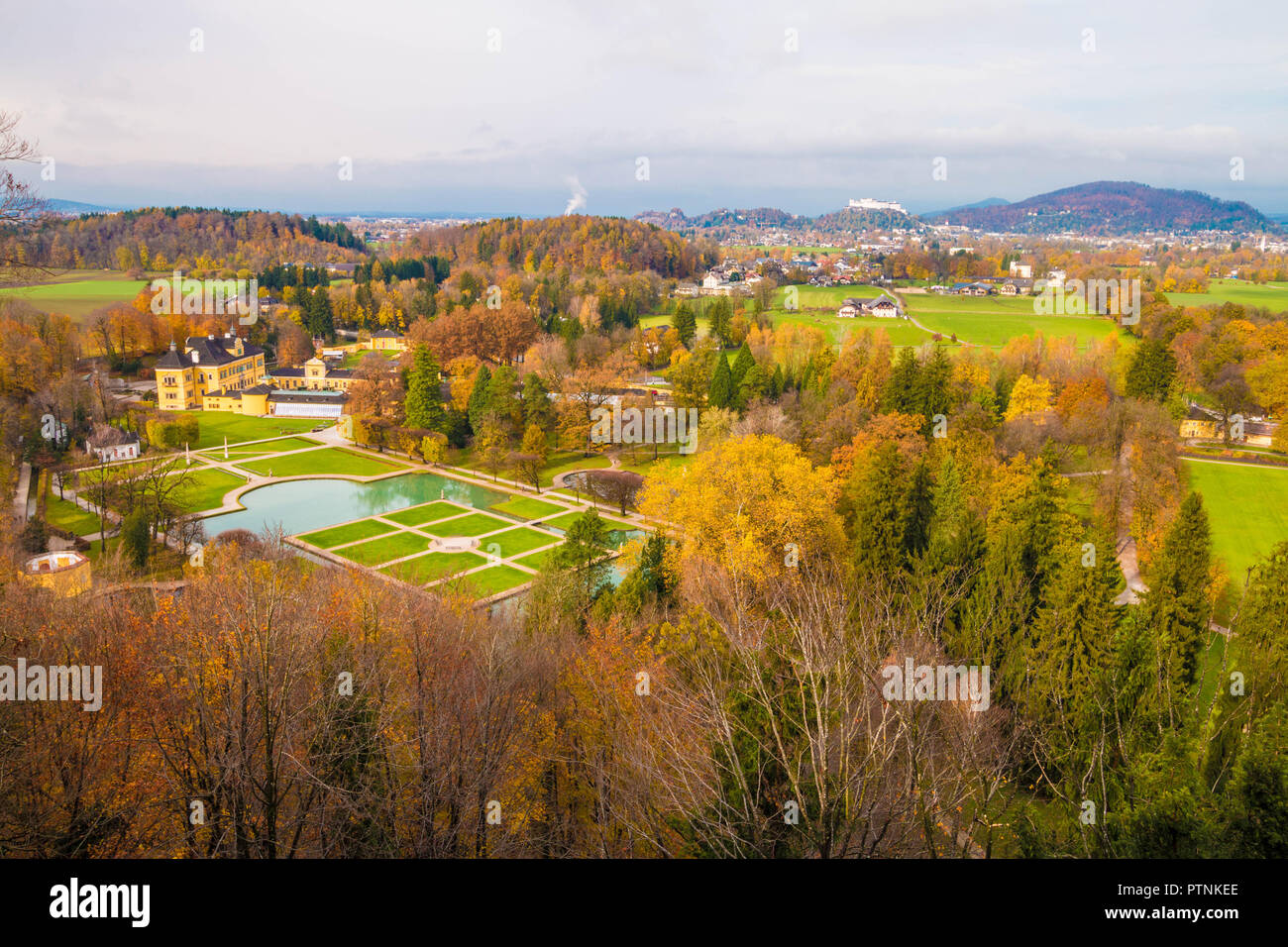 Vista panoramica del castello di Hellbrunn (Schloss Hellbrunn) e del parco in una bella giornata d'autunno. Il castello di Hohensalzburg visto sullo sfondo. Salisburgo, Austria. Foto Stock