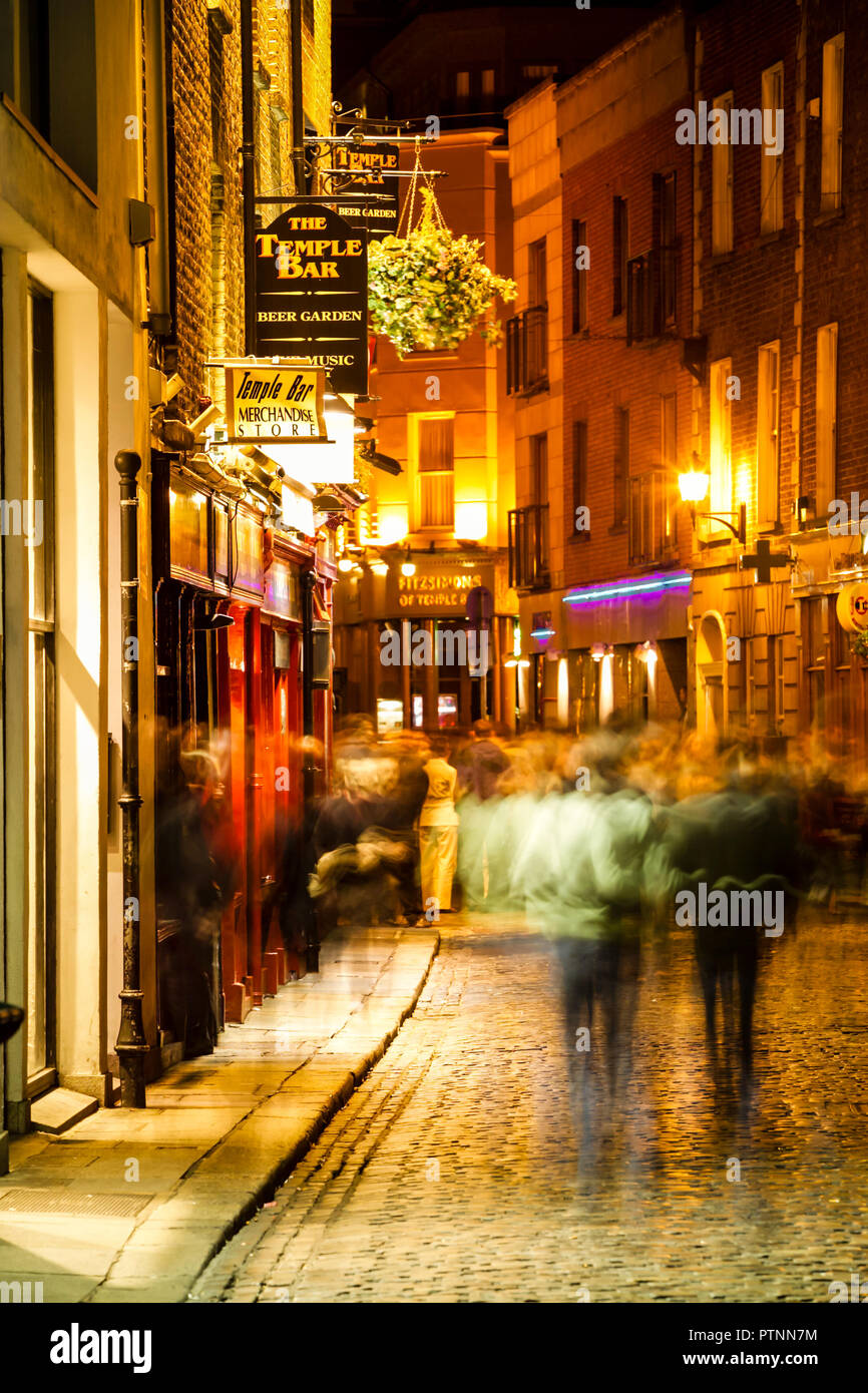 Occupato strada notturna scena con persone sfocate intorno al pub Temple Bar di Dublino città. Foto Stock