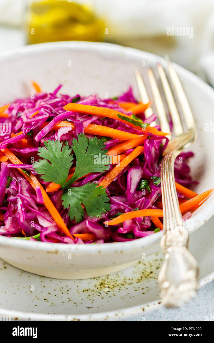 Cavolo rosso con insalata di carote, erbe e olio d'oliva e succo di limone condimento. Coleslaw. cole slaw . Luce cibo vegetariano. Messa a fuoco selettiva Foto Stock