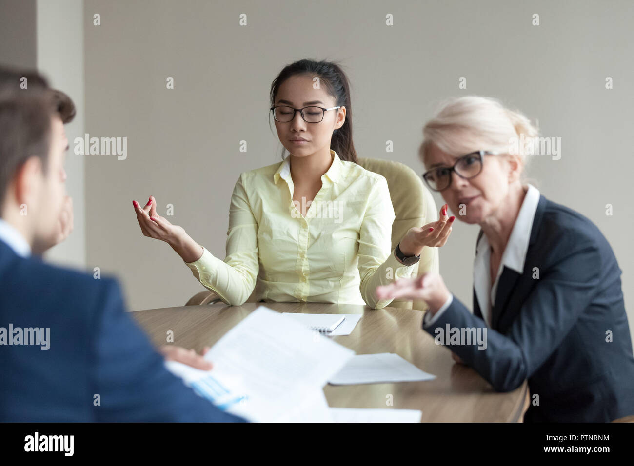 Calma impiegato femminile meditare alla riunione evitando conflitti Foto Stock