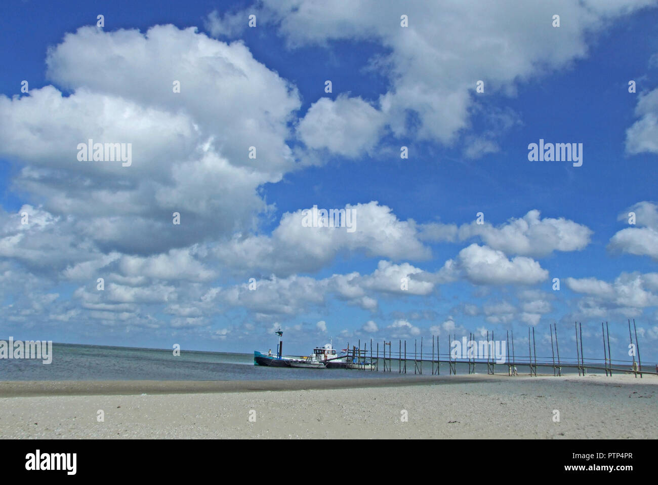 Piccola nave sotto un nuvoloso cielo blu Foto Stock