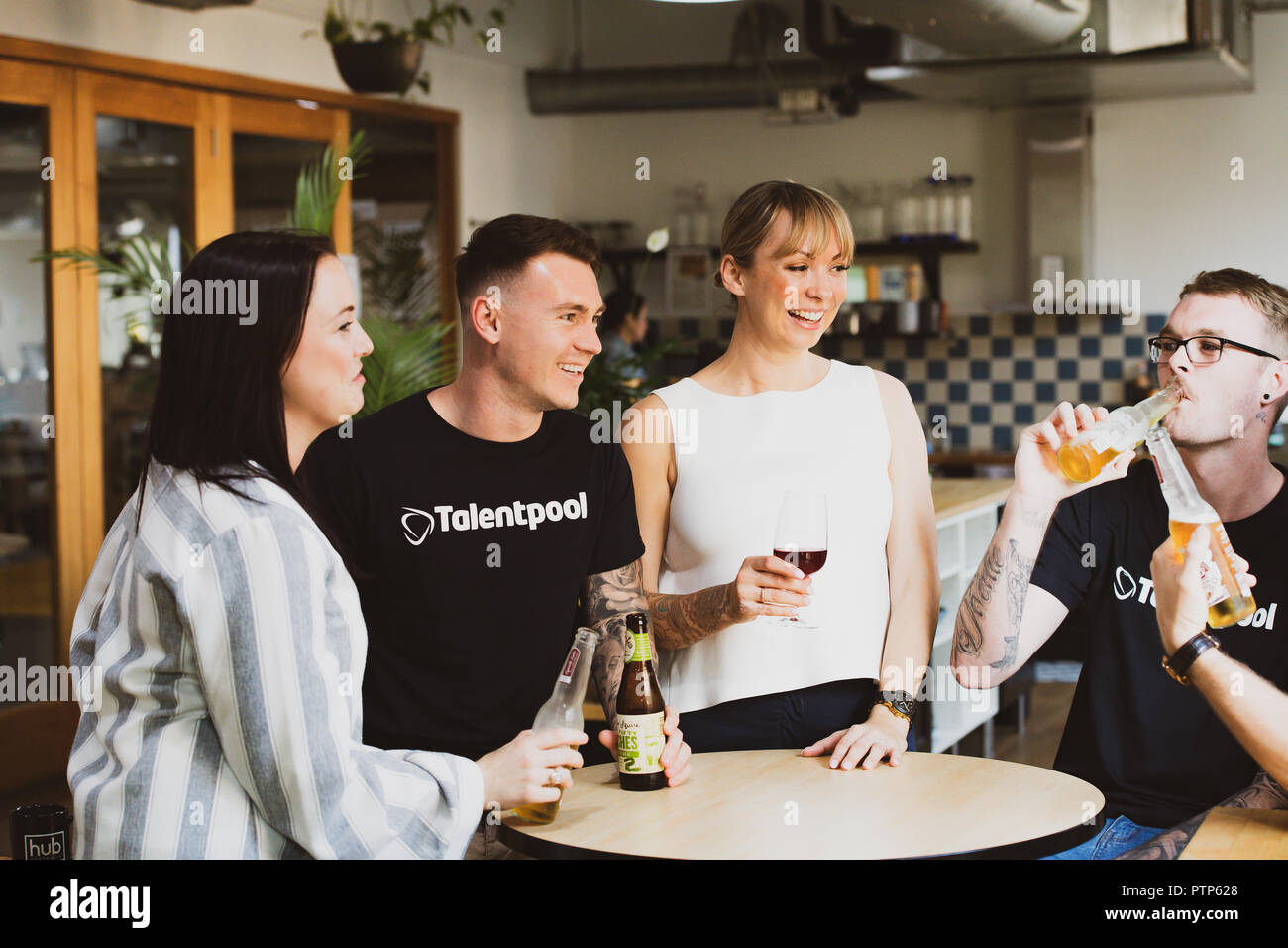 Gli imprenditori di rilassarsi dopo una giornata di duro lavoro con un paio di drink in un co-spazio di lavoro Foto Stock