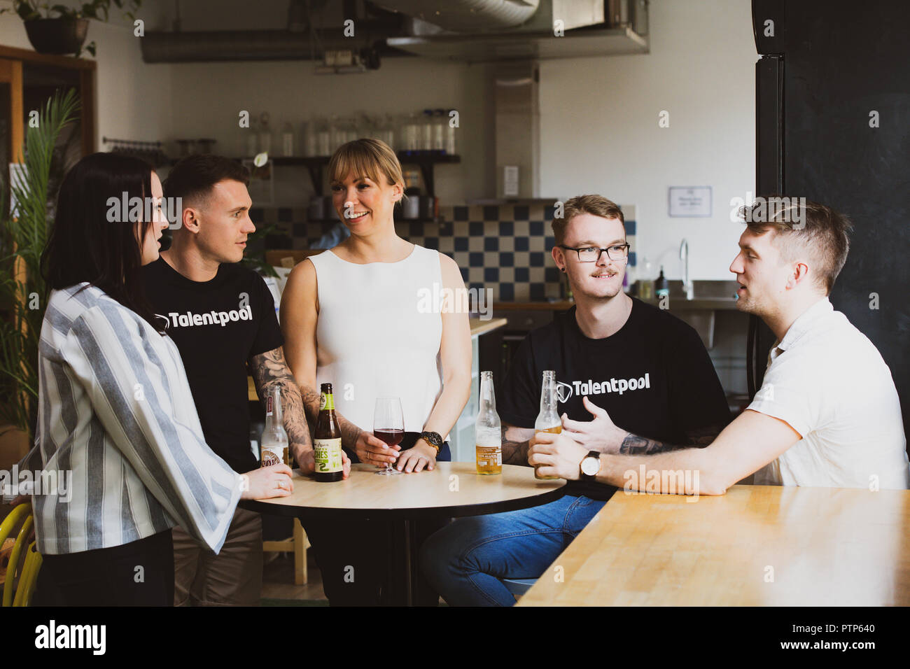 Gli imprenditori di rilassarsi dopo una giornata di duro lavoro con un paio di drink in un co-spazio di lavoro Foto Stock