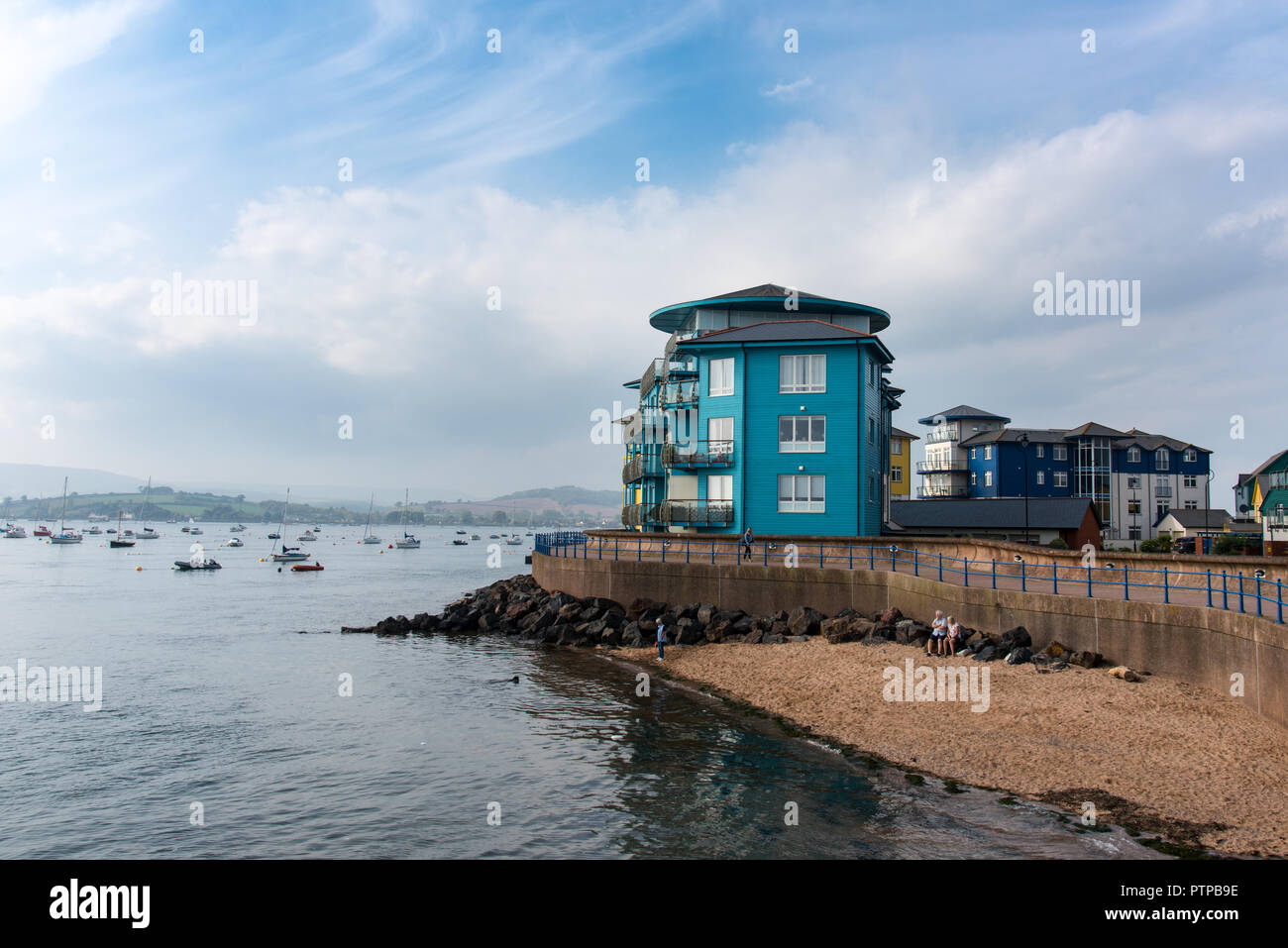 EXMOUTH, Devon, Regno Unito - 05Oct2018: piccola spiaggia accanto all'ingresso a Exmouth Docks con distintivi colorati edifici residenziali in Shelly behi su strada Foto Stock