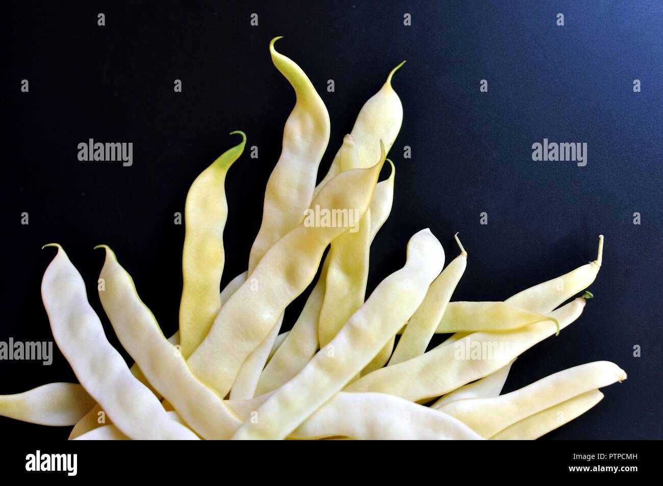 Close up della stringa verde fagioli freschi isolati su sfondo nero. Vista superiore Foto Stock