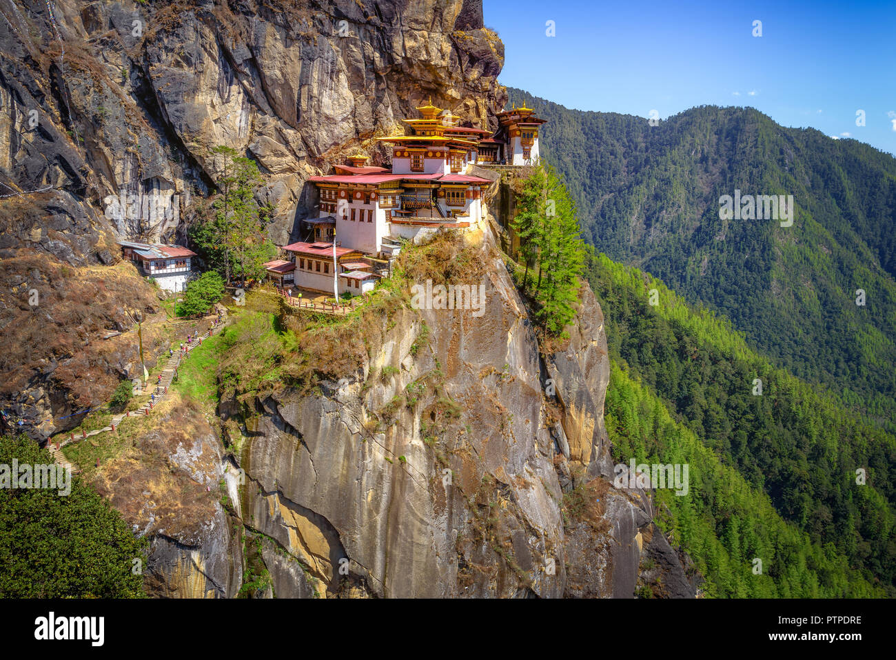 Tiger's Nest Monastero, Paro Taktsang, situato su una scogliera a paro, Bhutan, uno splendido scenario e lo sfondo delle montagne e degli alberi Foto Stock