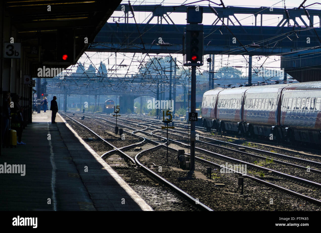 Figura solitaria in attesa del treno, soleggiata giornata autunnale a Sheffield Mildand stazione ferroviaria, Sheffield South Yorkshire, Inghilterra, Regno Unito Foto Stock