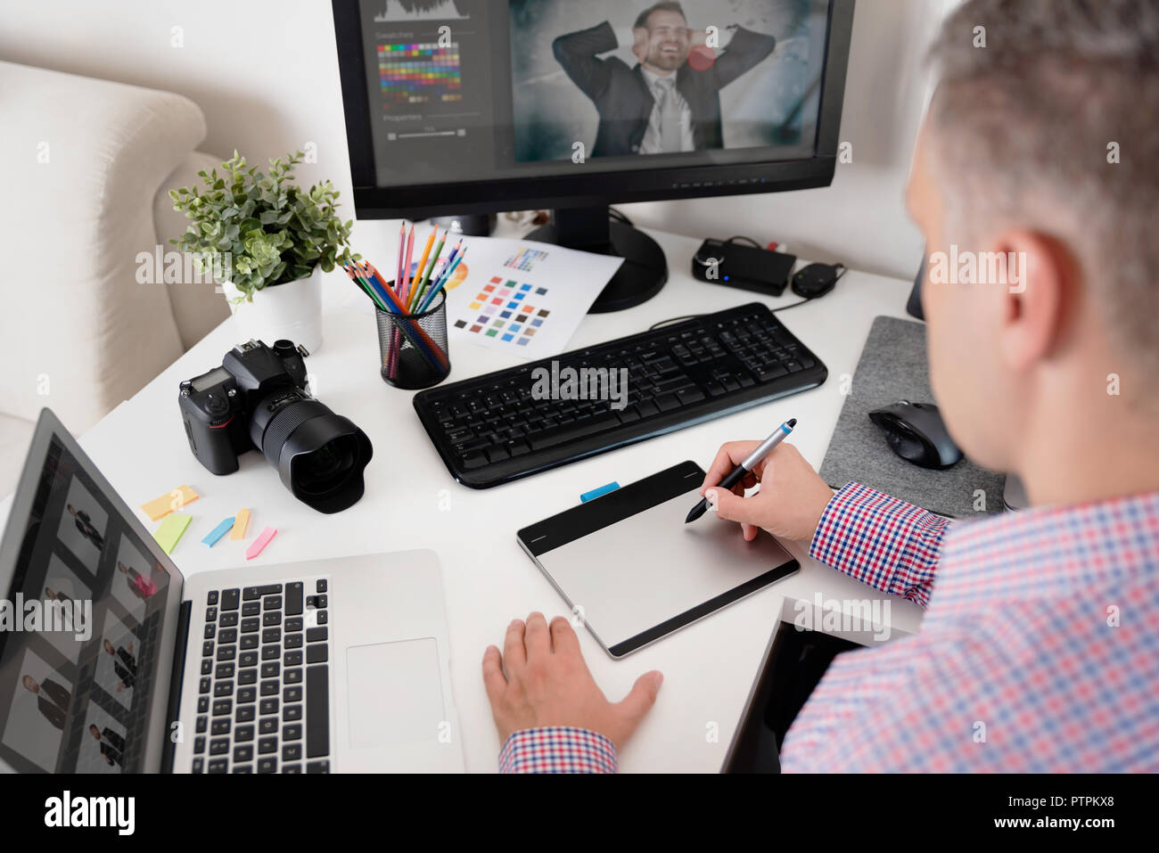 Retoucher lavora sulla fotografia. Graphic Designer utilizza una penna e tavoletta grafica Foto Stock