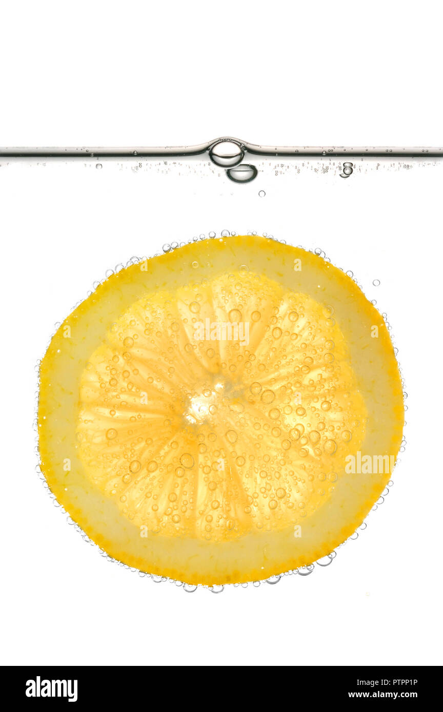 Fetta di limone giallo in acqua con bolle. Isolato su sfondo bianco. Foto Stock