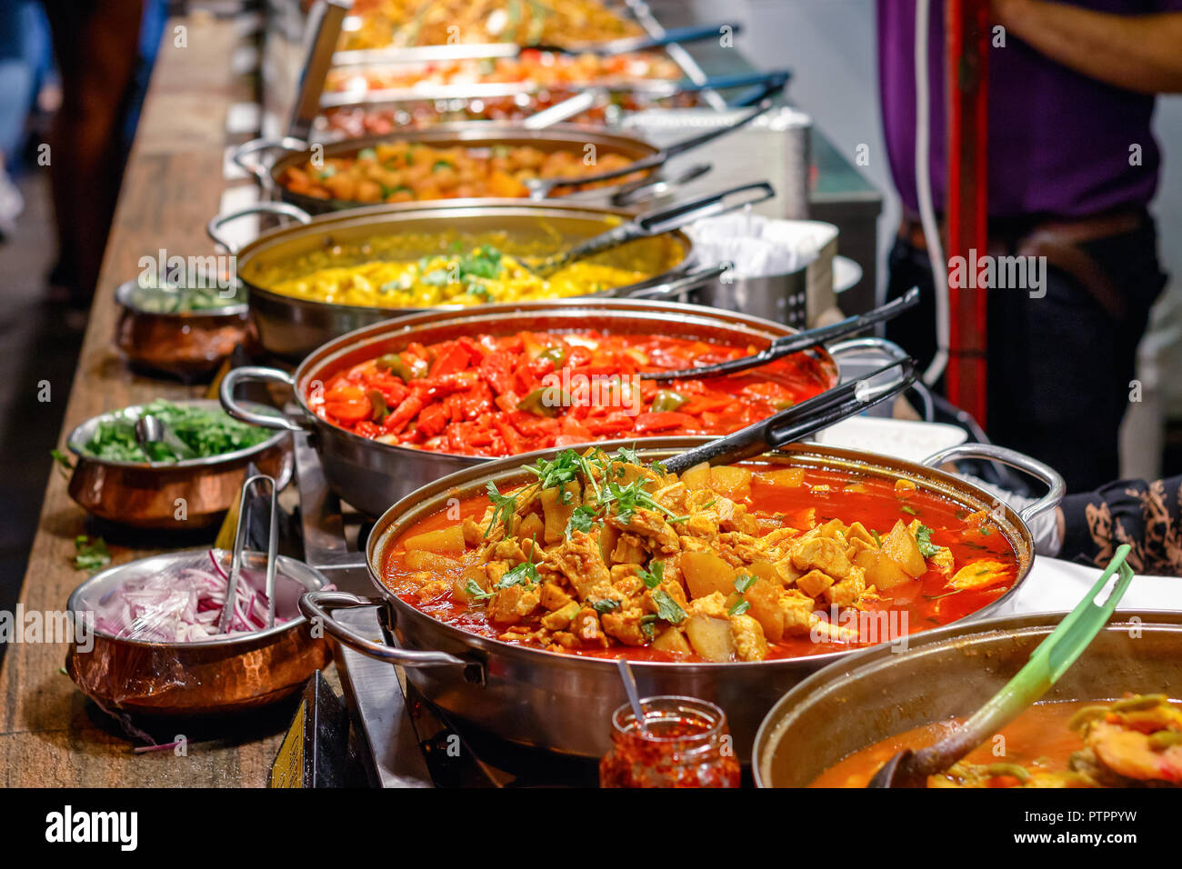 Varietà di curry cotti sul display presso il mercato di Camden a Londra Foto Stock