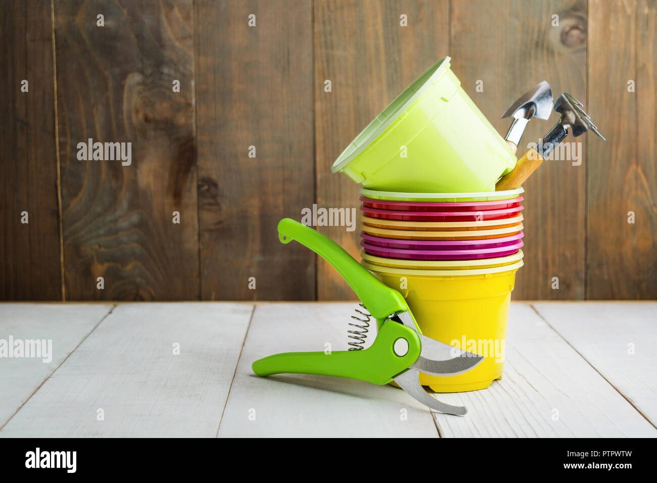 Attrezzi da giardino con colorati di plastica vuote pentole, giardino potatore e attrezzi per la semina, Home concetto di giardino con spazio di copia Foto Stock Attrezzi da giardino con colorati di plastica vuote pentole, giardino potatore e attrezzi per la semina, Home concetto di giardino con spazio di copia Foto Stock