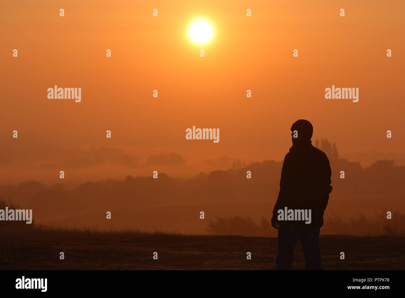 Una silhouette di un uomo guardando il sunrise Foto Stock