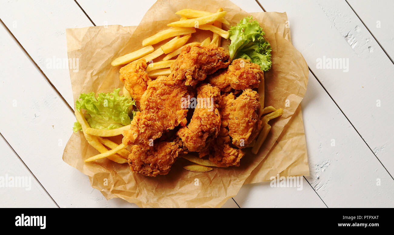Le lattughe e le patatine fritte in prossimità di ali di pollo Foto Stock