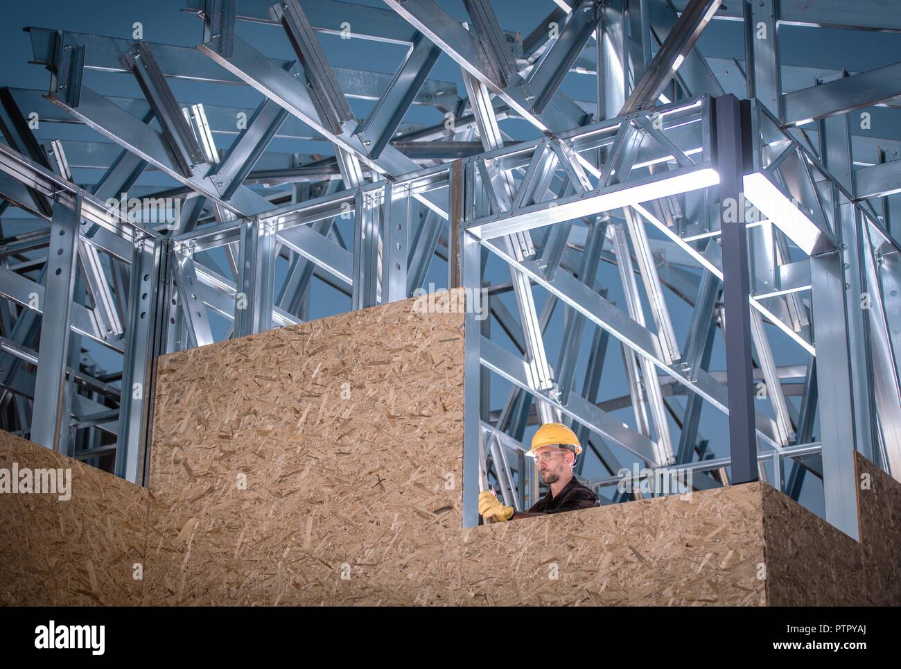 Metallo e Legno da costruzione. Scheletro dell'edificio e Caucasico lavoratore. Foto Stock