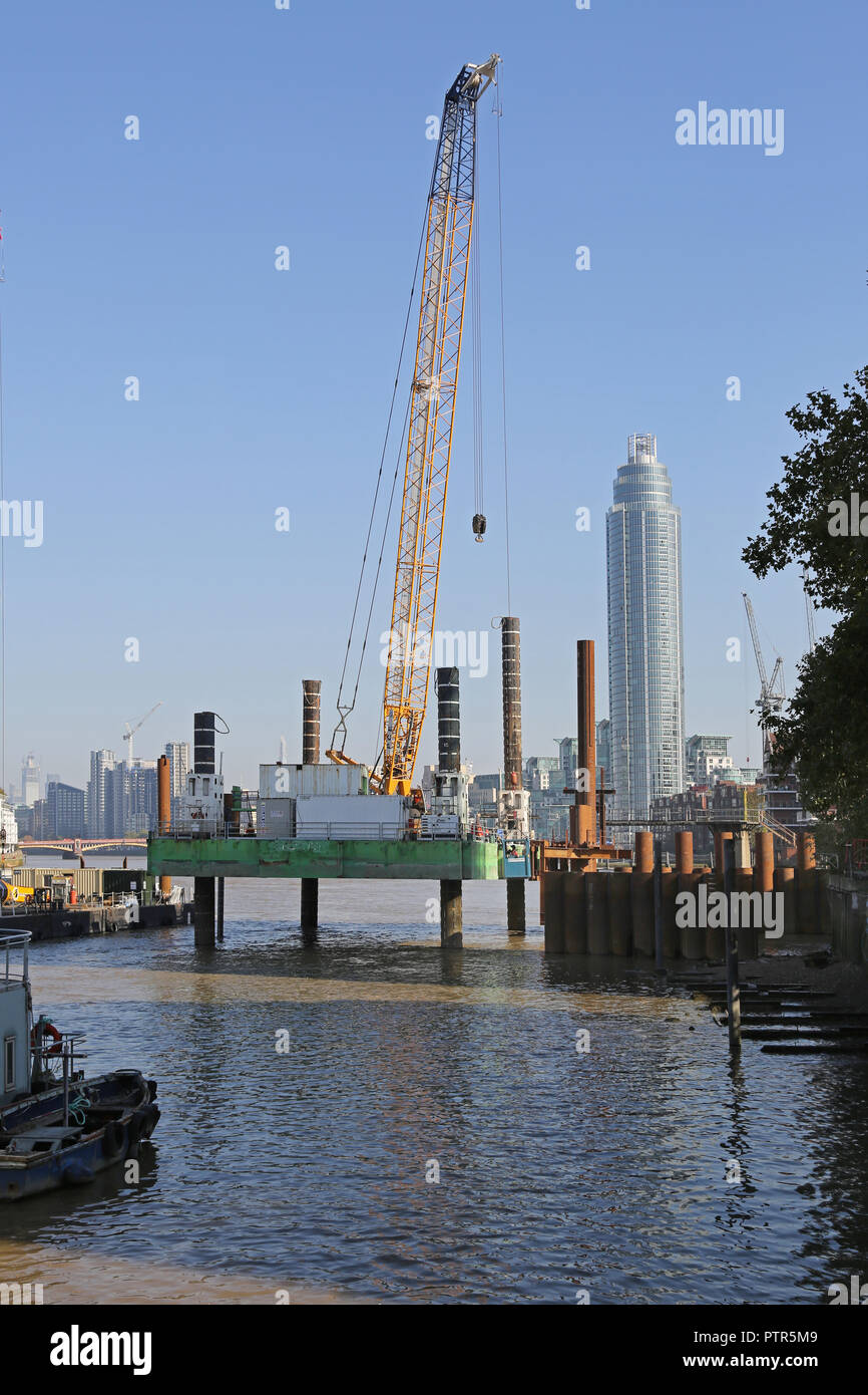 Un jack-up piattaforma è utilizzata per la costruzione di nuovi Thames Tideway super-fognature sulla riva sud del fiume Tamigi in Battersea, Londra, Regno Unito Foto Stock