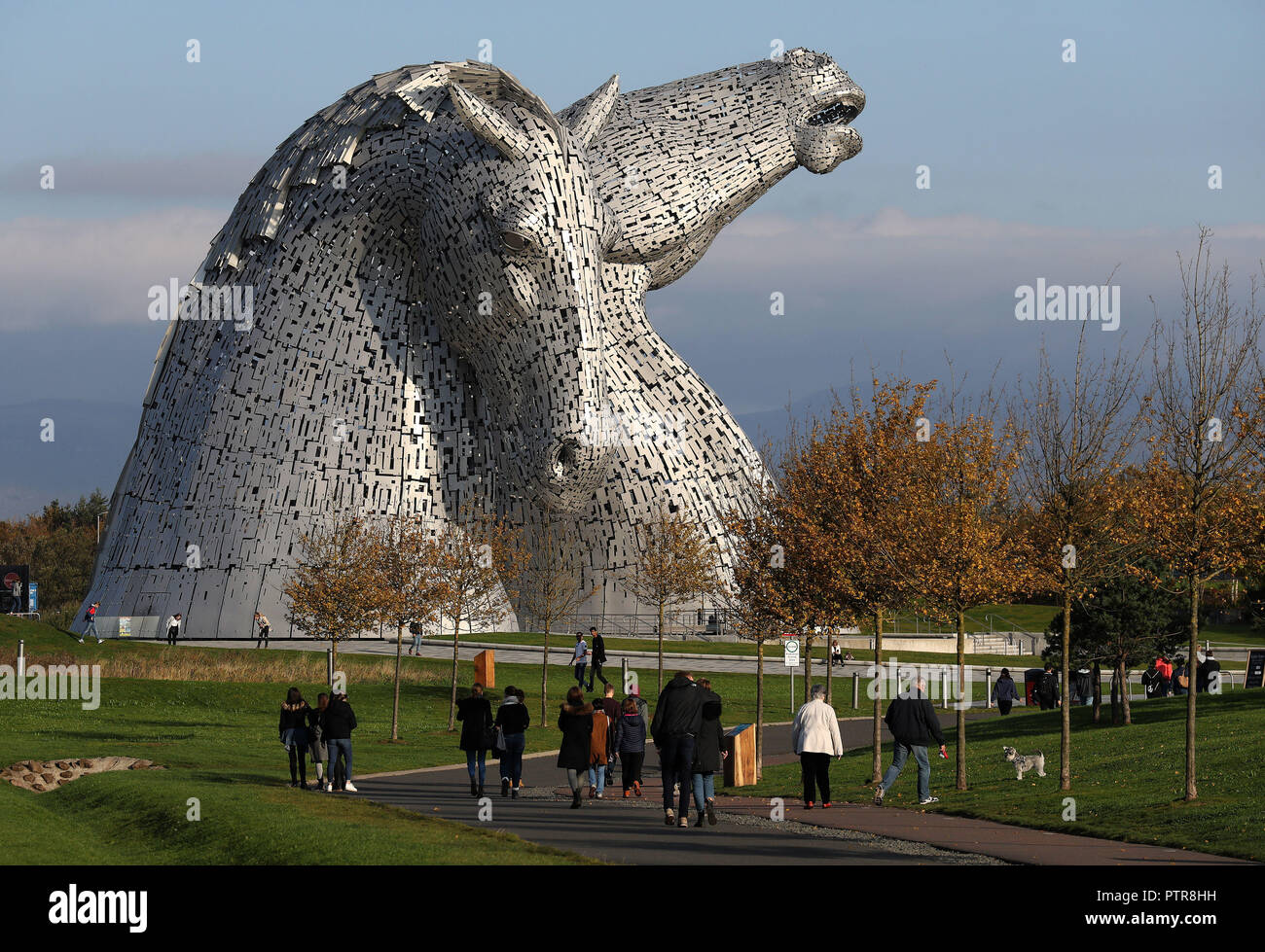 Le foglie degli alberi cambiano colore nelle mattina di sole autunnale al Kelpies a Falkirk. Foto Stock