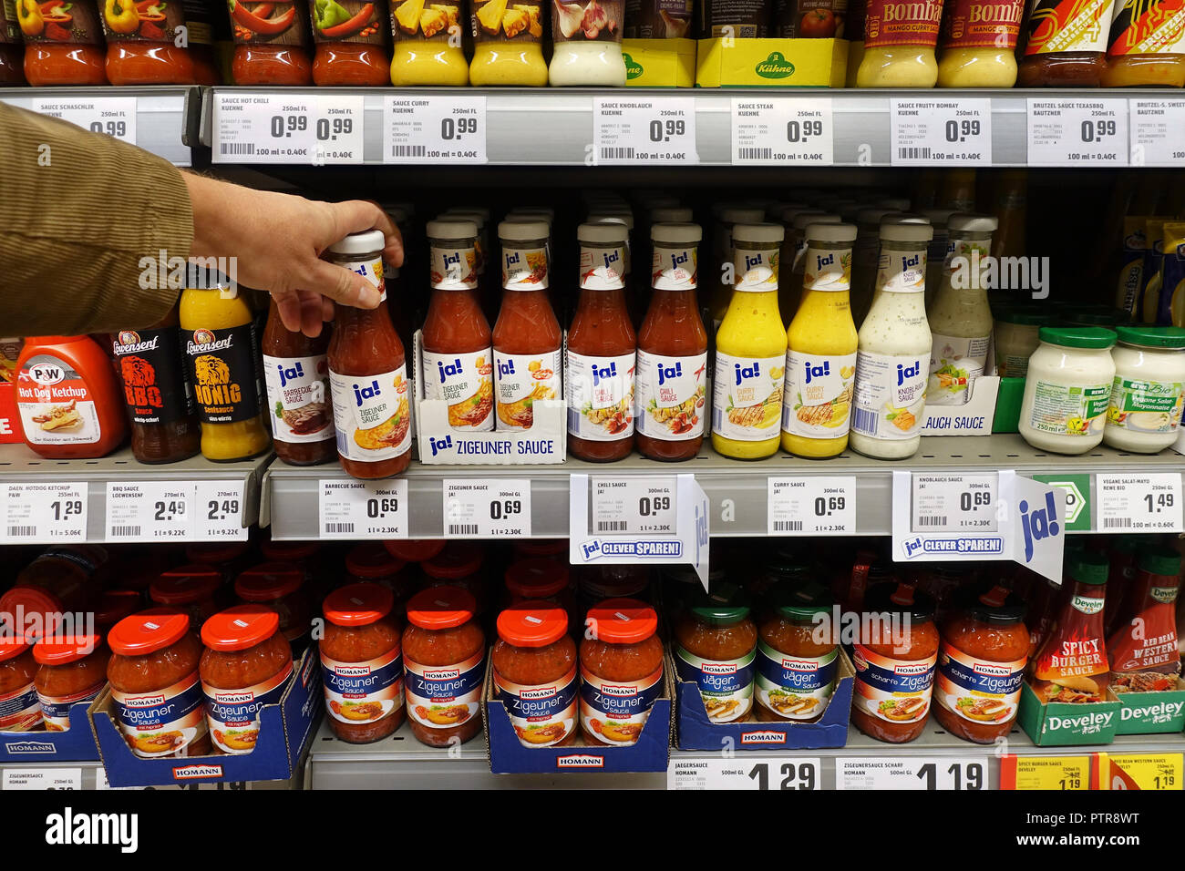 Salse di bottiglie in un supermercato REWE. Foto Stock