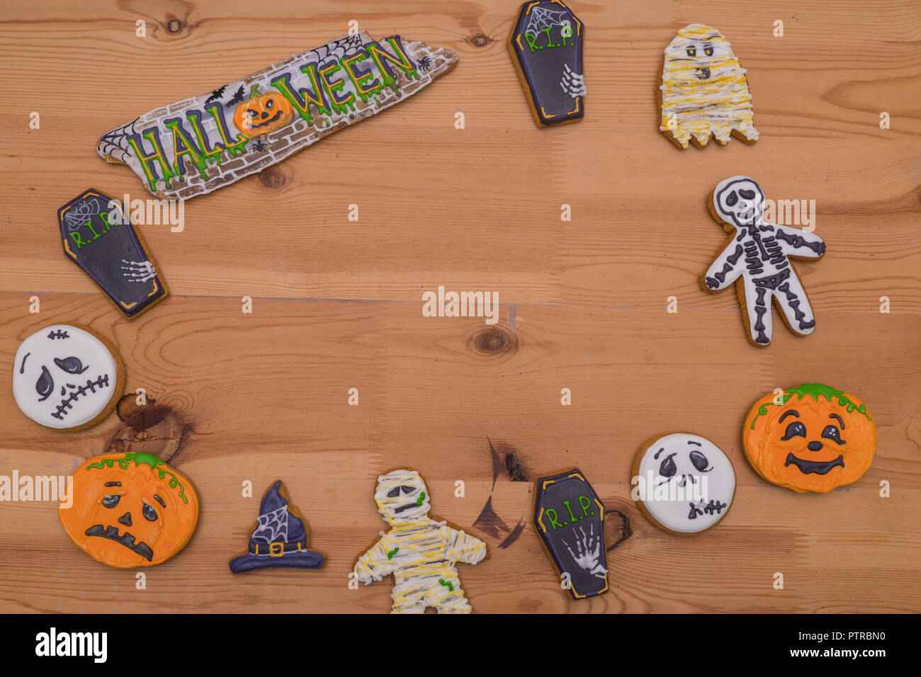 Dolce gingerbread emoticon fantasmi e zucche, streghe cappelli su una tavola di legno. Preparazione per la festa di Halloween. Dolci per la festa Foto Stock
